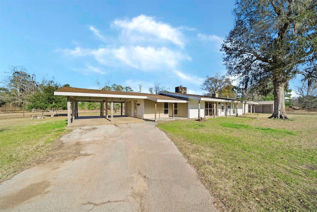 ranch-style house with a front yard and a carport