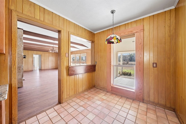 interior space with beam ceiling, crown molding, light hardwood / wood-style floors, and wood walls