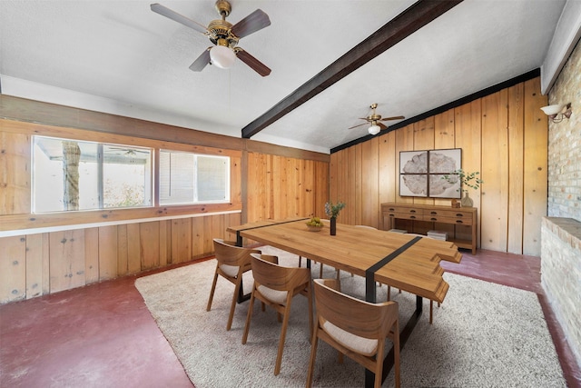 dining area with wood walls, vaulted ceiling with beams, and ceiling fan