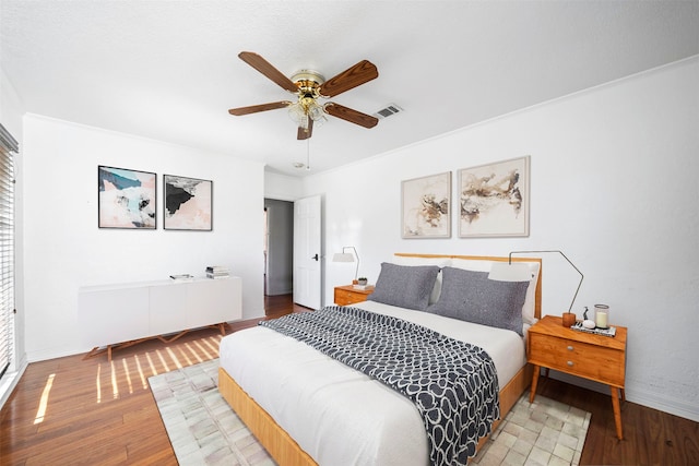 bedroom featuring crown molding, hardwood / wood-style flooring, and ceiling fan