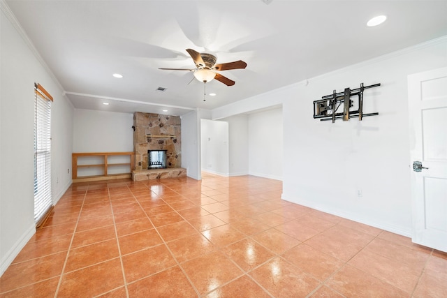 unfurnished living room featuring a stone fireplace, ornamental molding, plenty of natural light, and light tile patterned floors