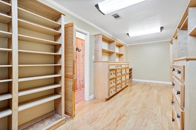 walk in closet with light hardwood / wood-style floors