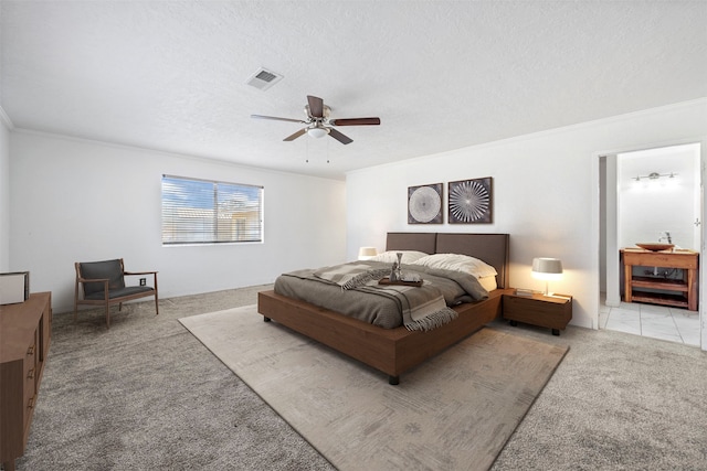 bedroom featuring crown molding, a textured ceiling, light colored carpet, and ceiling fan