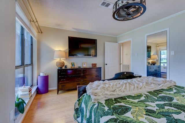 bedroom with crown molding and light wood-type flooring