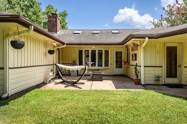 back of property featuring a patio and a lawn