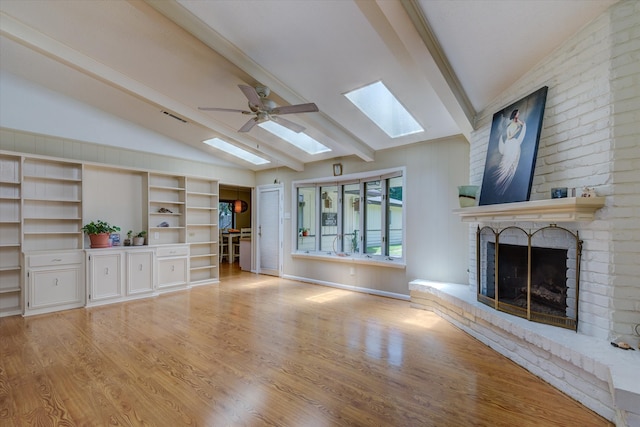 unfurnished living room featuring vaulted ceiling with beams, ceiling fan, a fireplace, and light wood-type flooring