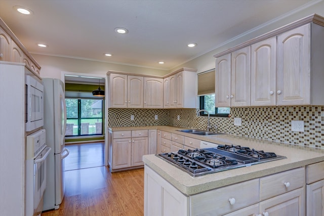 kitchen featuring white appliances, tasteful backsplash, sink, light wood-type flooring, and ornamental molding