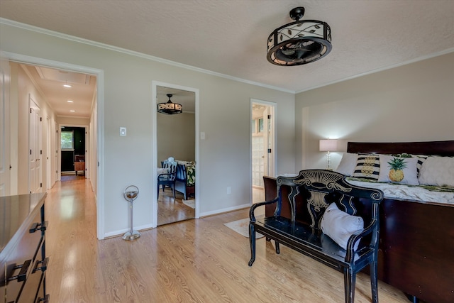 bedroom with crown molding, light hardwood / wood-style flooring, and a textured ceiling