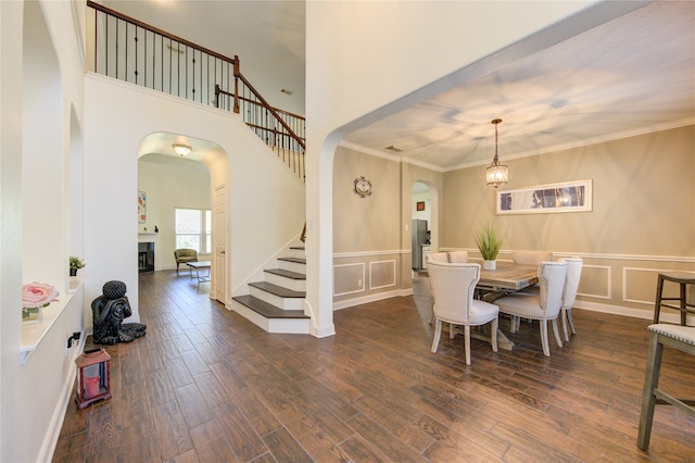 dining room with crown molding, dark hardwood / wood-style flooring, and a chandelier