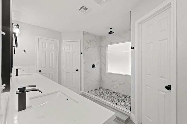 bathroom featuring a tile shower and vanity