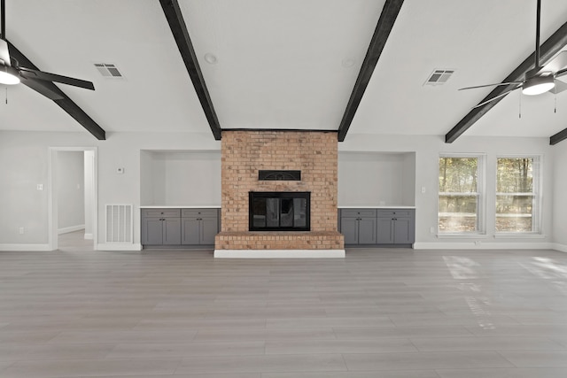 unfurnished living room with a brick fireplace, light wood-type flooring, and ceiling fan