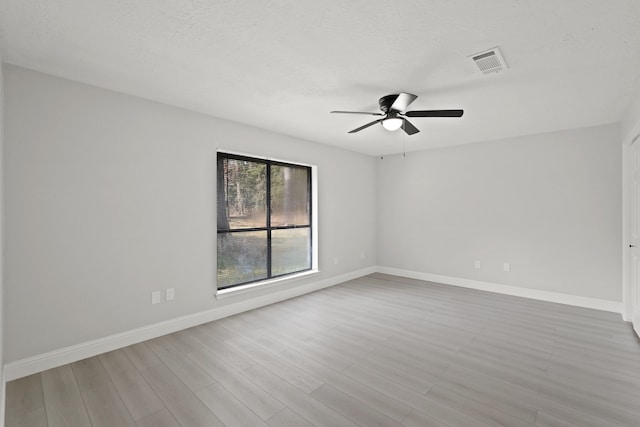 unfurnished room featuring light hardwood / wood-style floors, a textured ceiling, and ceiling fan