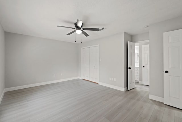 unfurnished bedroom featuring a closet, ceiling fan, a textured ceiling, and light hardwood / wood-style floors