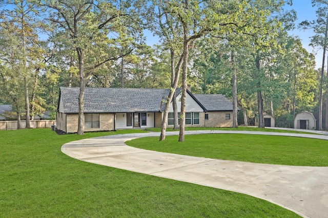 ranch-style house featuring a storage unit and a front yard