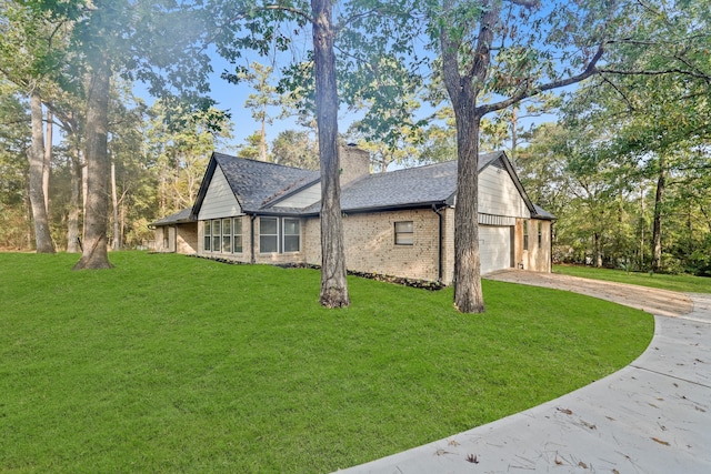 view of side of property featuring a garage and a lawn