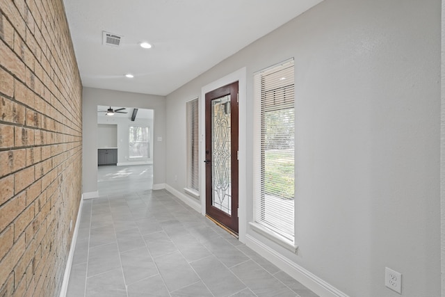 foyer entrance with light tile patterned floors and ceiling fan