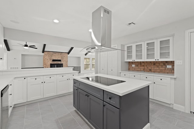 kitchen featuring black electric stovetop, a kitchen island, island range hood, white cabinetry, and gray cabinets