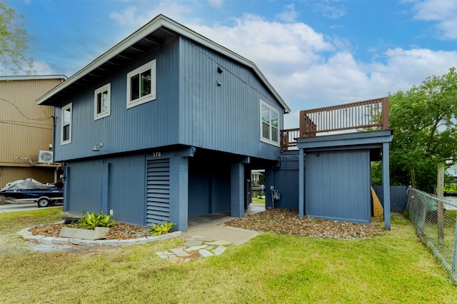 rear view of house with ac unit and a yard