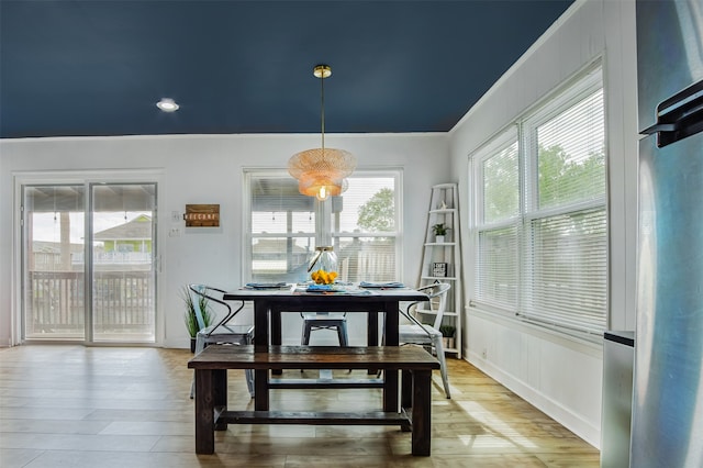 dining room featuring light wood-type flooring and crown molding