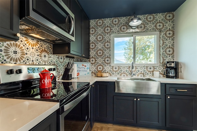 kitchen featuring backsplash, appliances with stainless steel finishes, sink, and light wood-type flooring