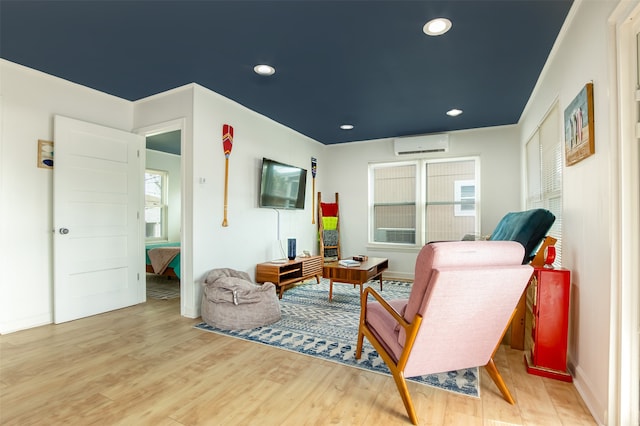 living room featuring light hardwood / wood-style floors and a wall mounted AC