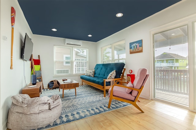 sitting room featuring a wall mounted AC and wood-type flooring