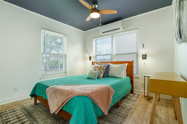 bedroom featuring a wall unit AC, wood-type flooring, multiple windows, and ceiling fan