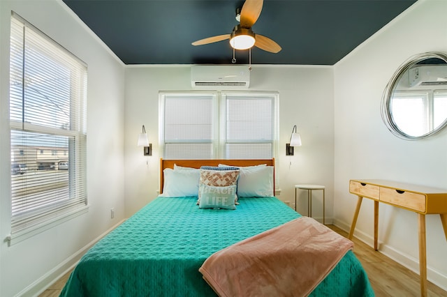 bedroom with ornamental molding, hardwood / wood-style floors, ceiling fan, and a wall mounted air conditioner