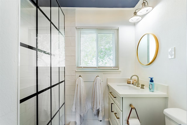 bathroom featuring tiled shower, vanity, and toilet