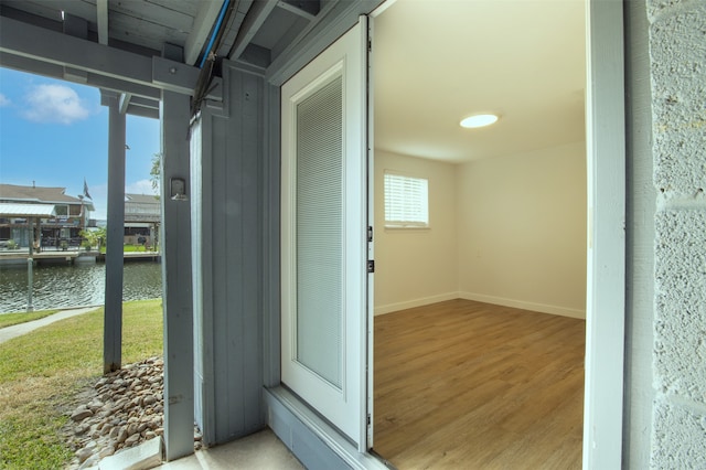 hallway featuring a water view and wood-type flooring