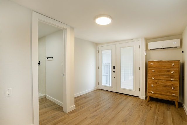 entryway featuring light hardwood / wood-style flooring, french doors, and a wall mounted air conditioner