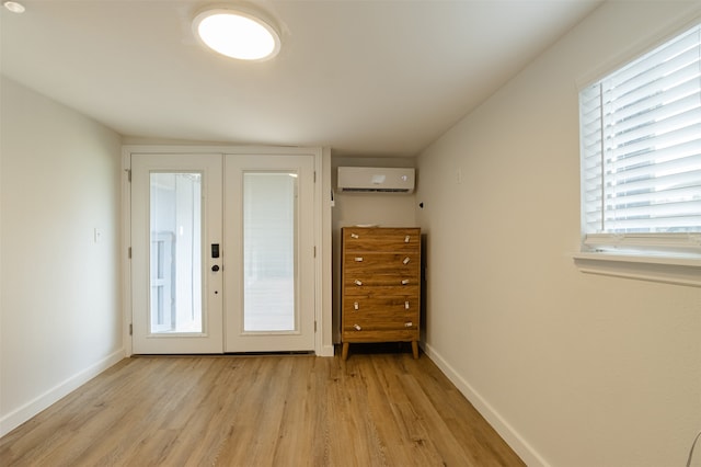 doorway featuring a wall mounted AC, french doors, and light hardwood / wood-style flooring