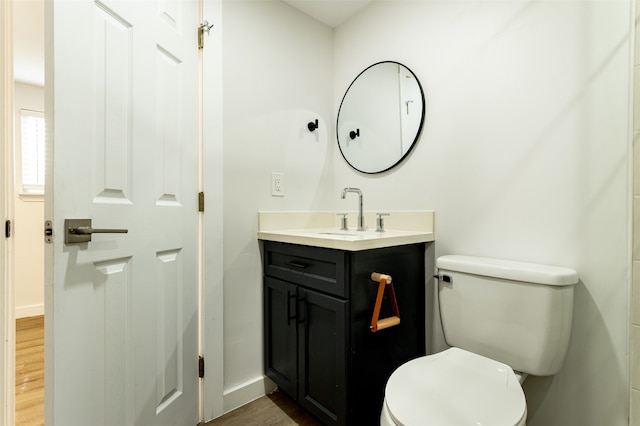 bathroom with hardwood / wood-style floors, vanity, and toilet