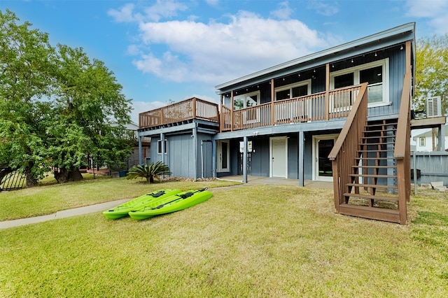 rear view of property with a lawn and a wooden deck