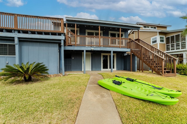 rear view of property featuring a wooden deck and a yard