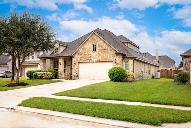 view of front facade with a front lawn, a garage, and cooling unit