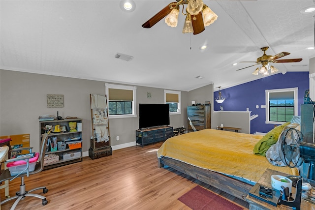 bedroom with multiple windows, wood-type flooring, lofted ceiling, and ceiling fan