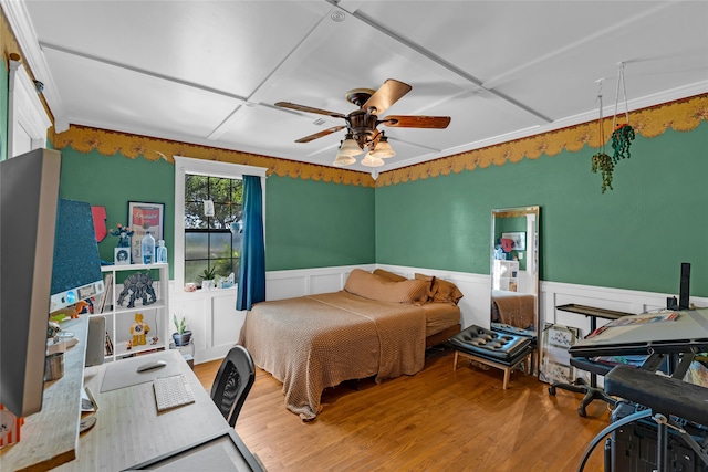 bedroom featuring crown molding, wood-type flooring, and ceiling fan