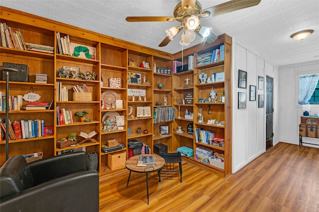 living area featuring ceiling fan, a textured ceiling, and hardwood / wood-style floors