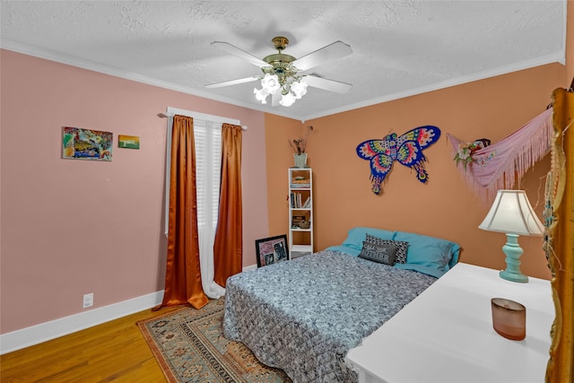 bedroom featuring hardwood / wood-style floors, crown molding, a textured ceiling, and ceiling fan