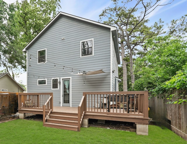 rear view of property with a wooden deck and a yard