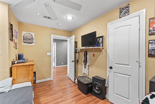 workout room featuring ceiling fan and light wood-type flooring