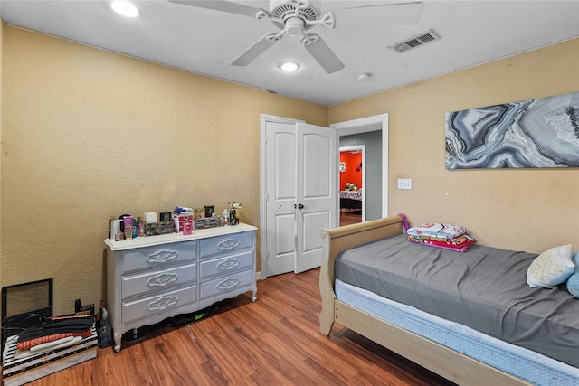 bedroom with a closet, dark hardwood / wood-style floors, and ceiling fan