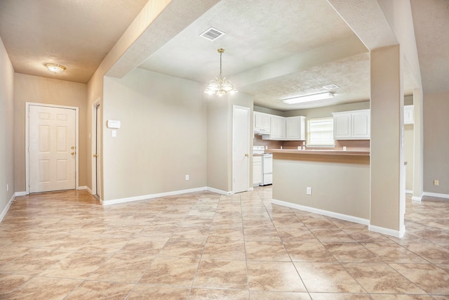 interior space featuring visible vents, baseboards, a textured ceiling, and a chandelier