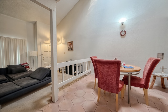 tiled dining area featuring vaulted ceiling