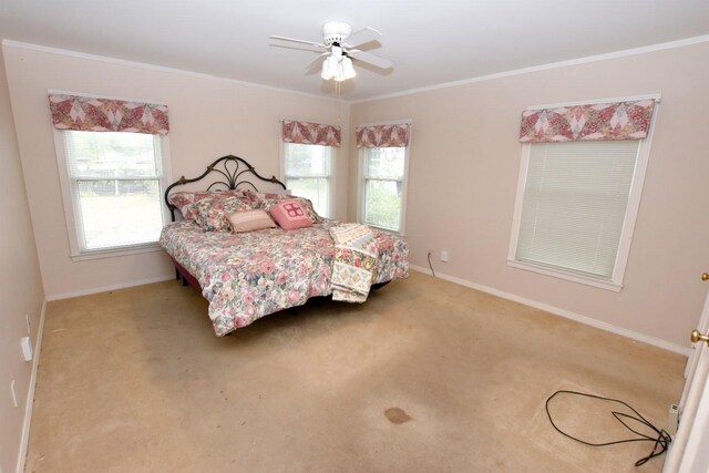 carpeted bedroom featuring ceiling fan and crown molding