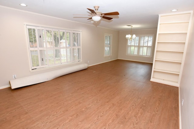 unfurnished room featuring wood-type flooring, ceiling fan with notable chandelier, and ornamental molding