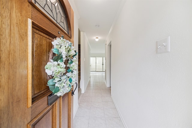 corridor with ornamental molding and light tile patterned floors