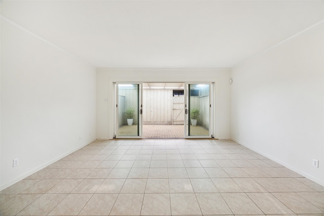 tiled spare room featuring crown molding