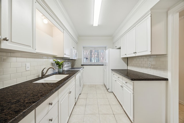 kitchen with white appliances, decorative backsplash, sink, and white cabinets